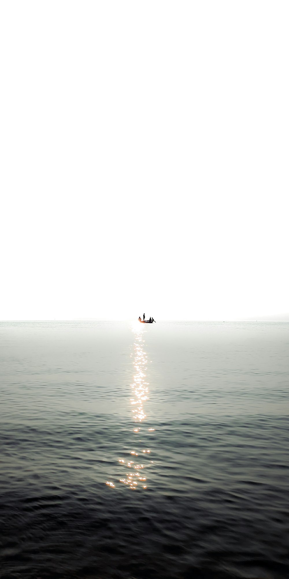 a small boat floating on top of a large body of water