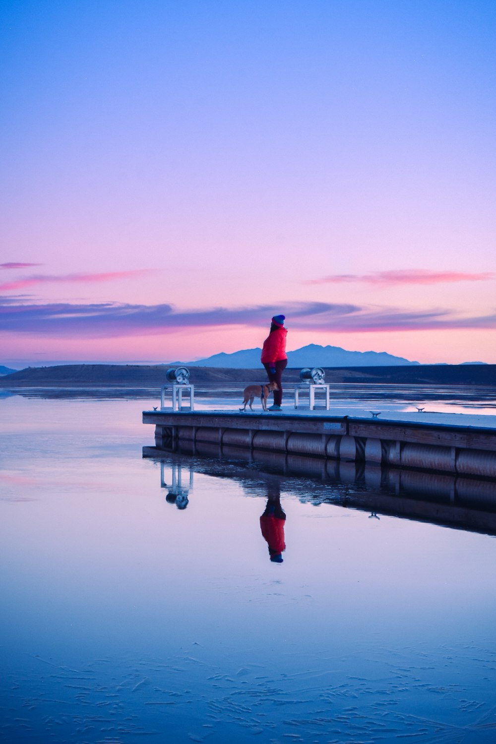 a person sitting on a bench next to a body of water