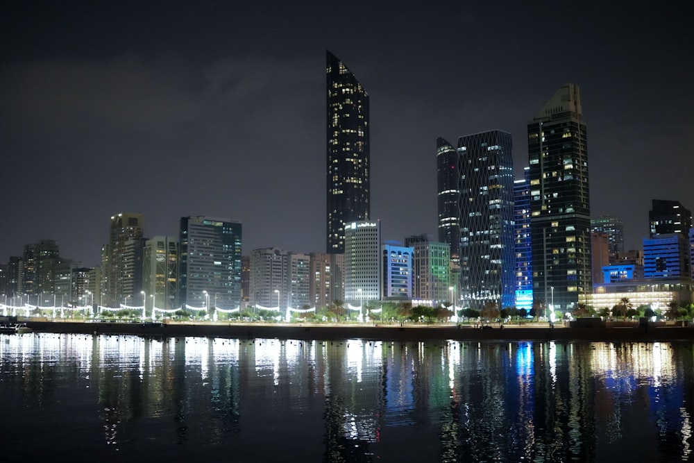 a city at night with lights reflecting in the water