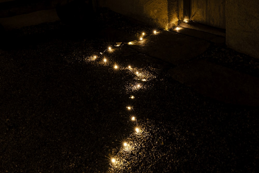 a path of lights on the ground in the dark