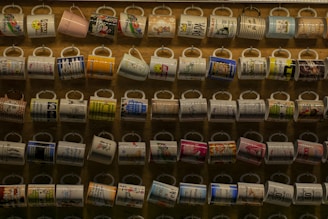 A variety of mugs featuring unique designs on a wooden table.