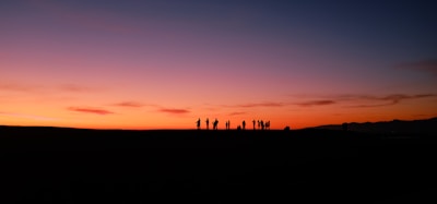 Sunset view over Mont Passot with silhouettes of travelers admiring the colorful sky.