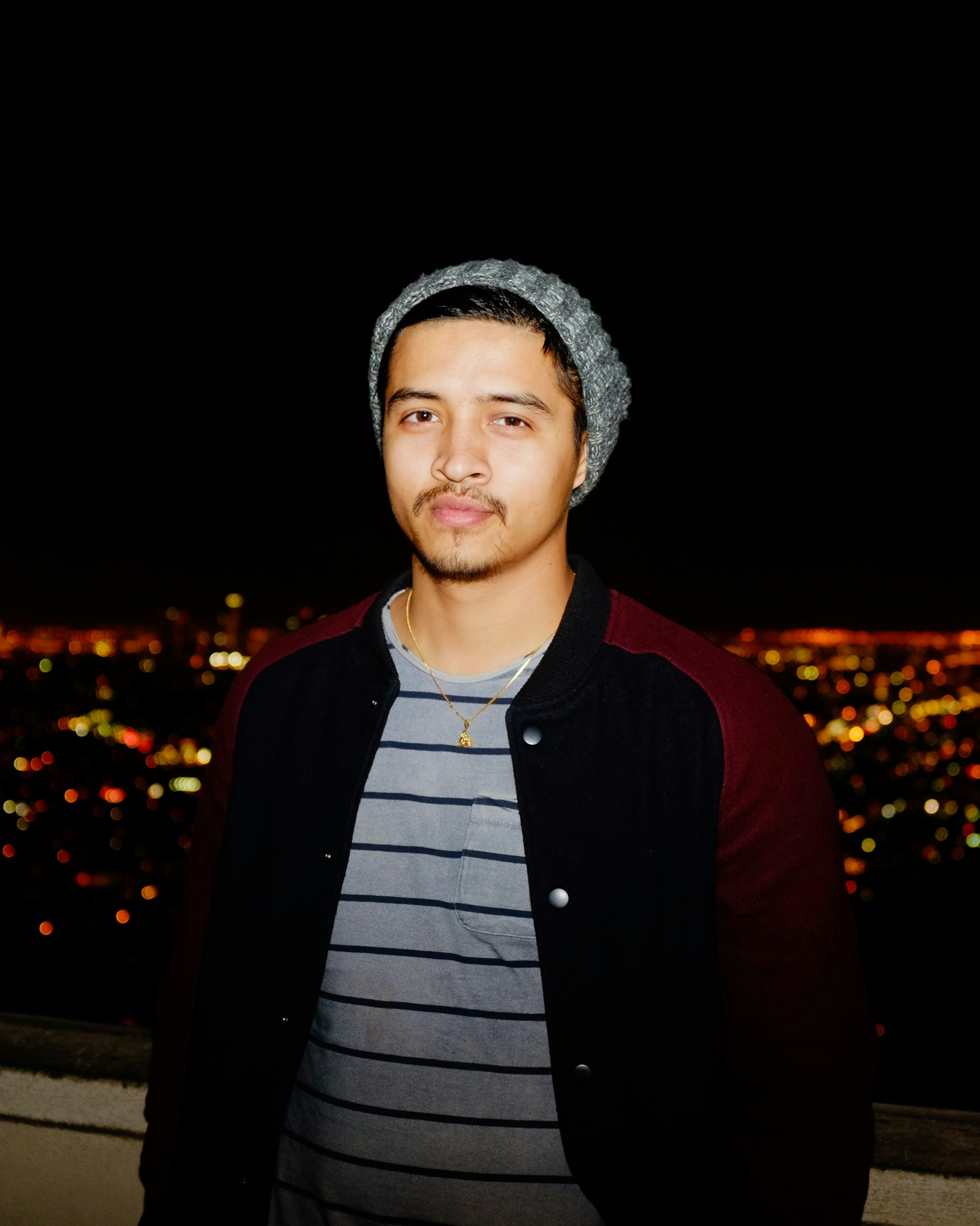 a man standing in front of a city at night