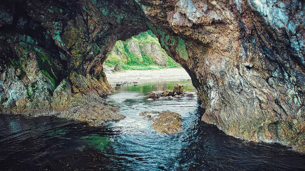 a river flowing through a cave filled with rocks