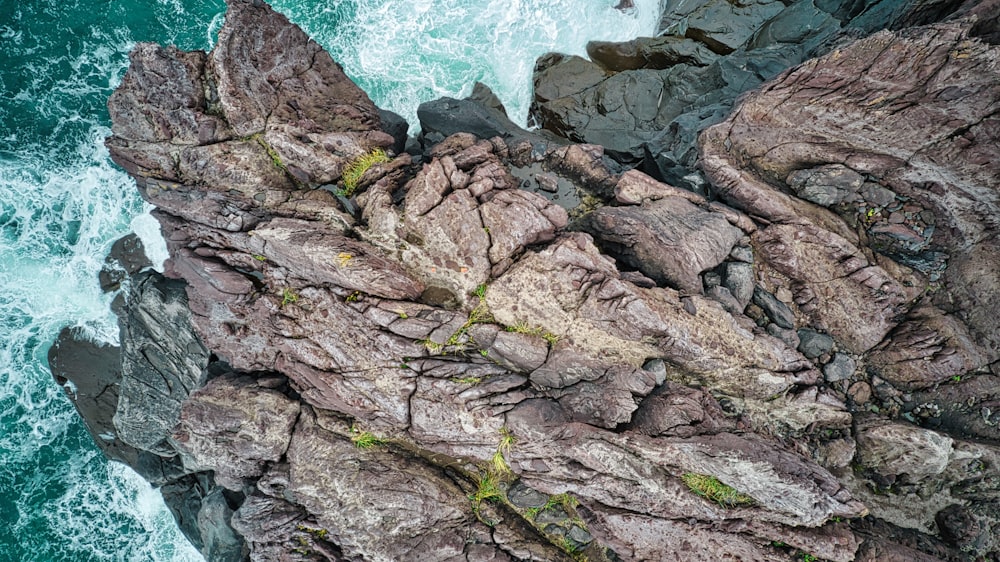 an aerial view of a rocky coastline with blue water