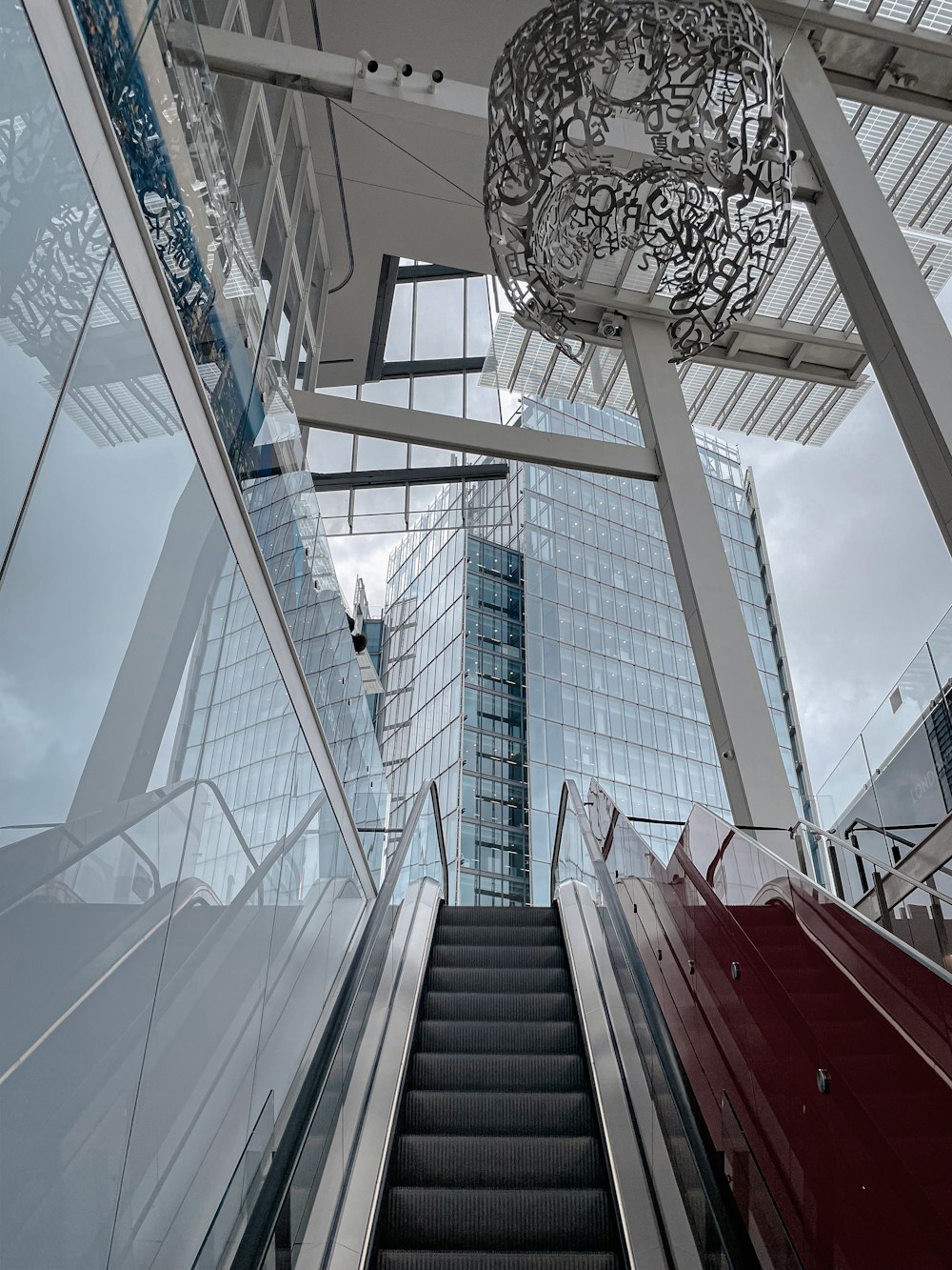 an escalator with a chandelier hanging from the ceiling