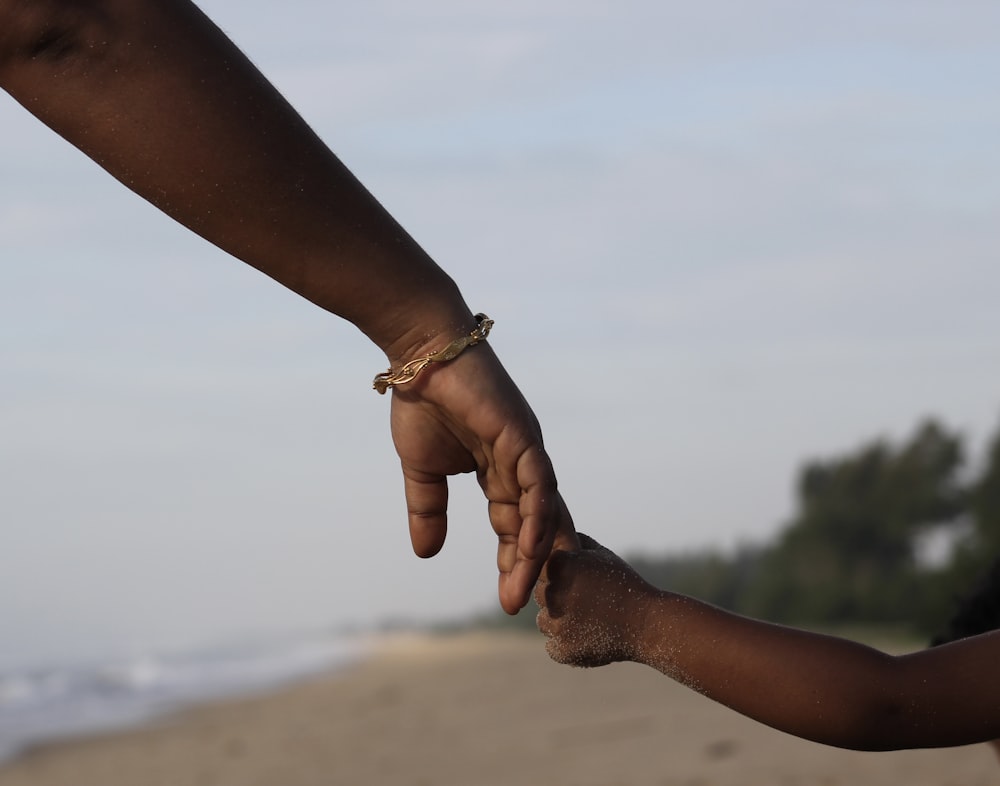 a close up of two people holding hands