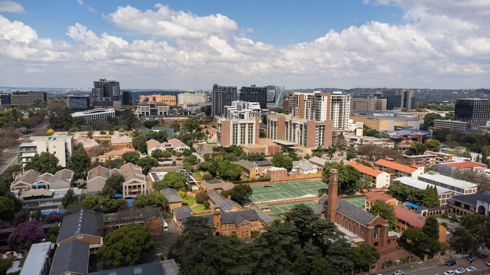 a view of a city with a tennis court in the foreground