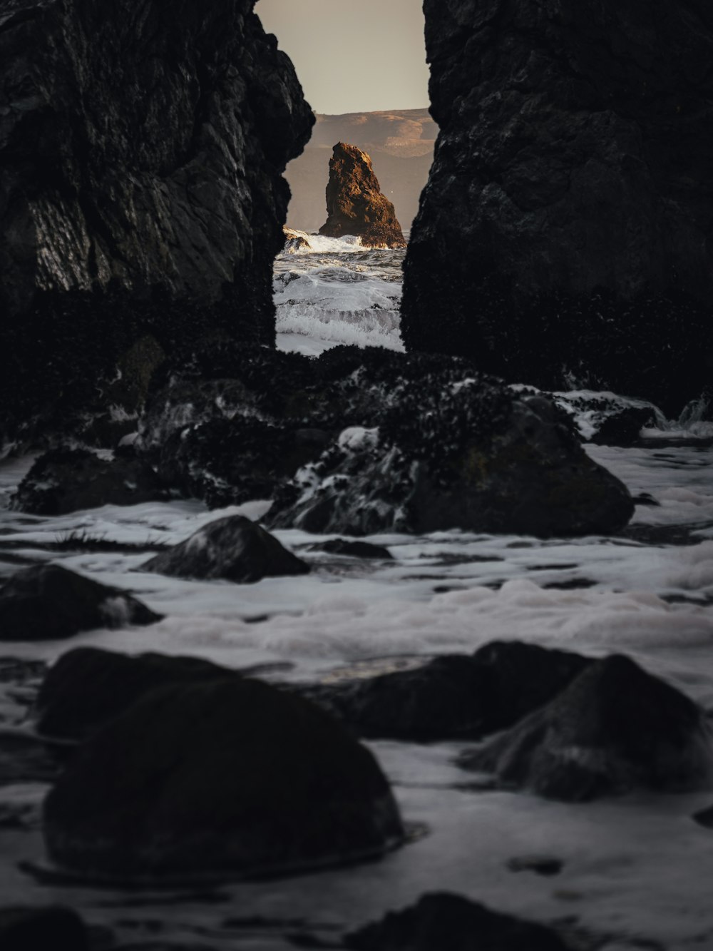 a view of the ocean through some rocks