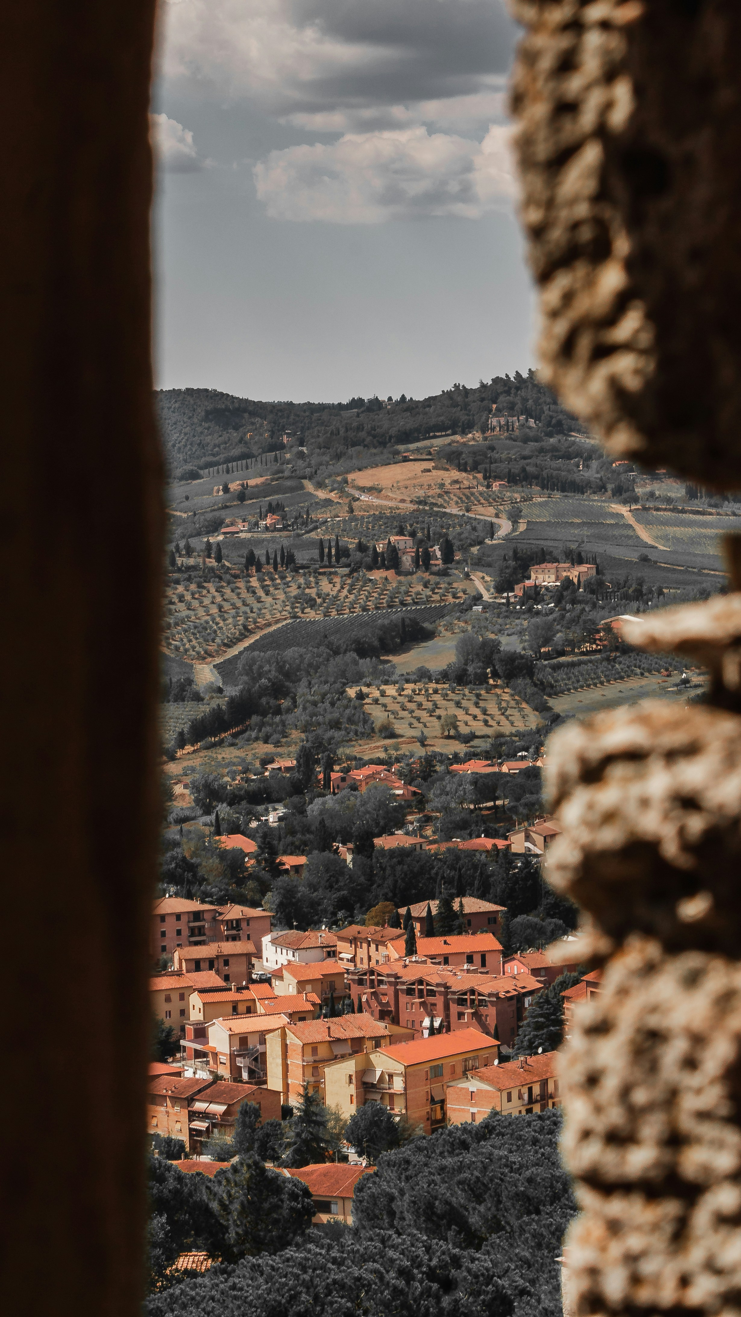 a view of a town from a window in a stone wall