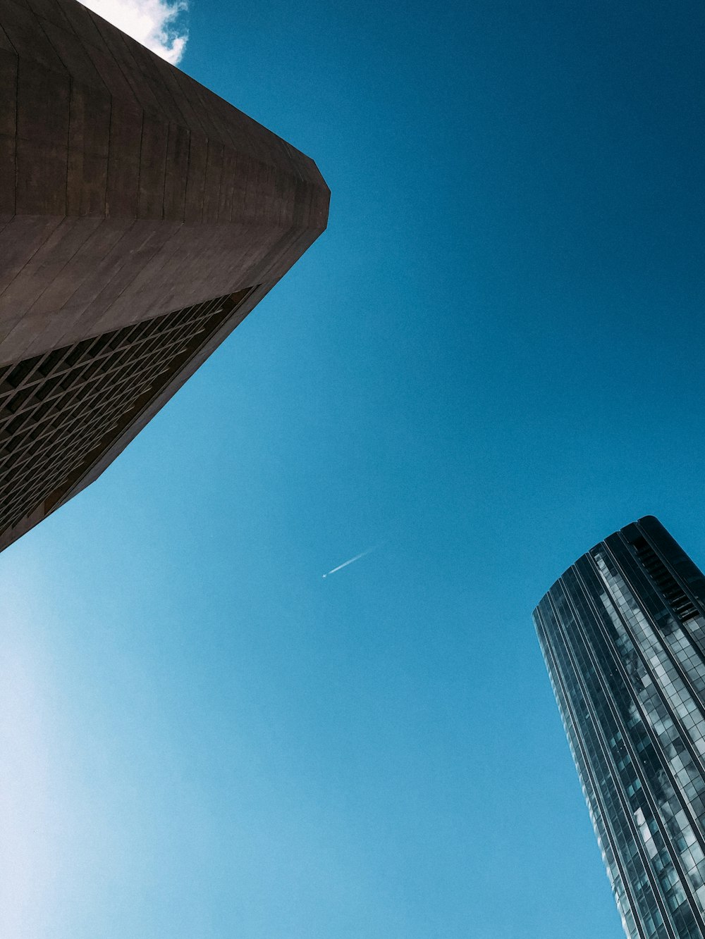 a tall building with a plane flying in the sky