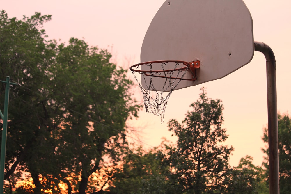 a basketball hoop with the sun setting in the background