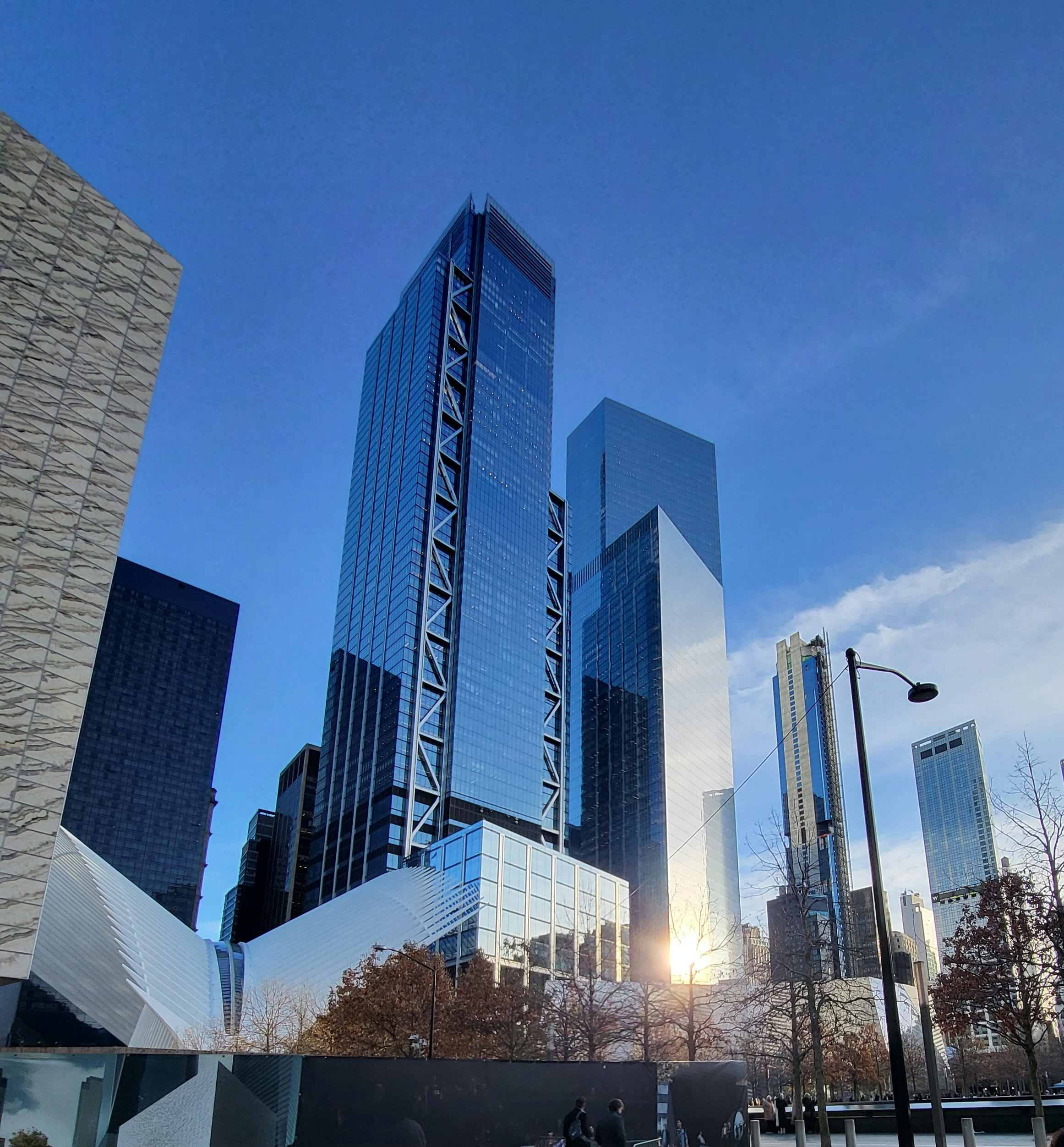 A group of people walking down a street next to tall buildings photo ...