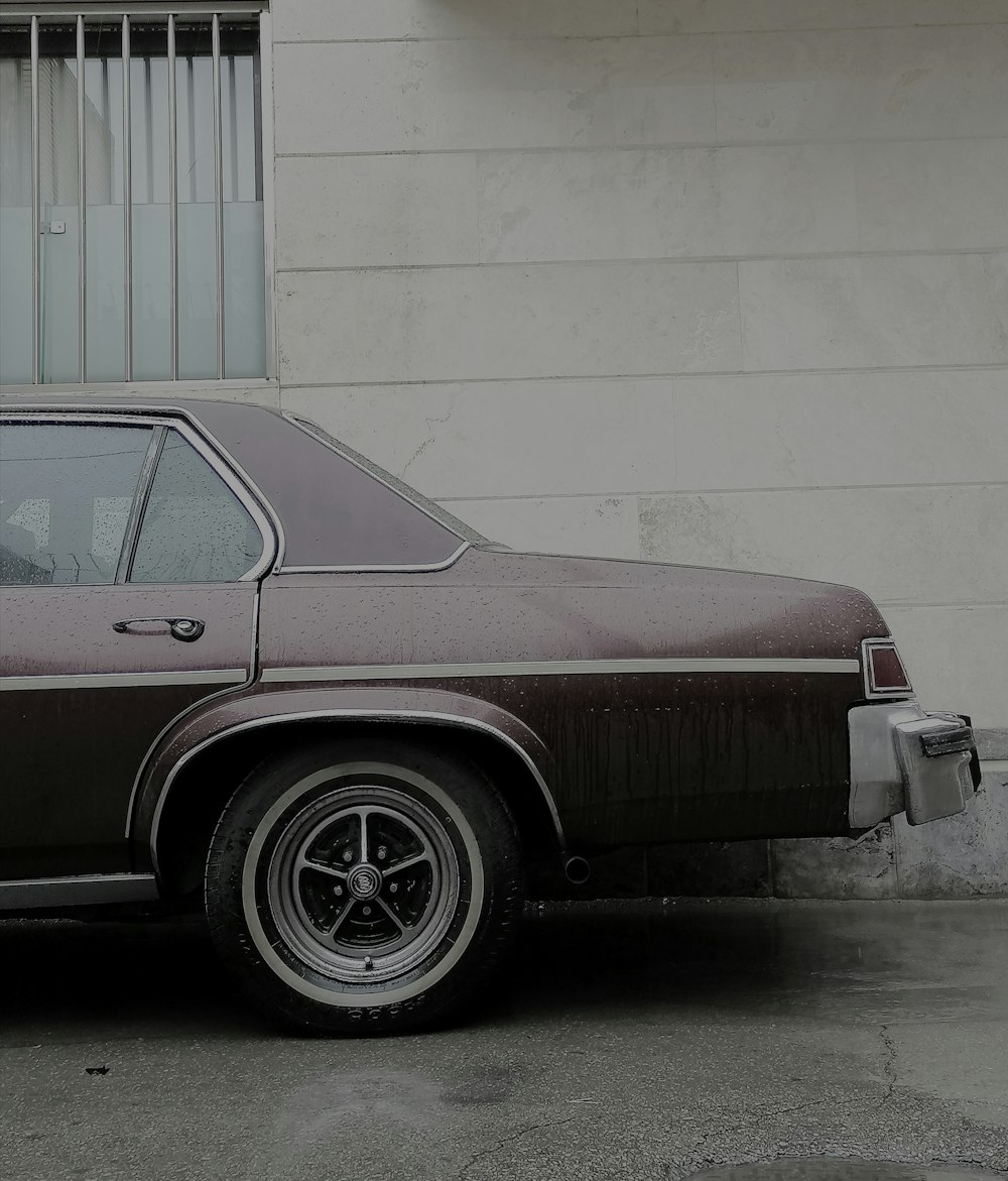 a brown car parked in front of a building