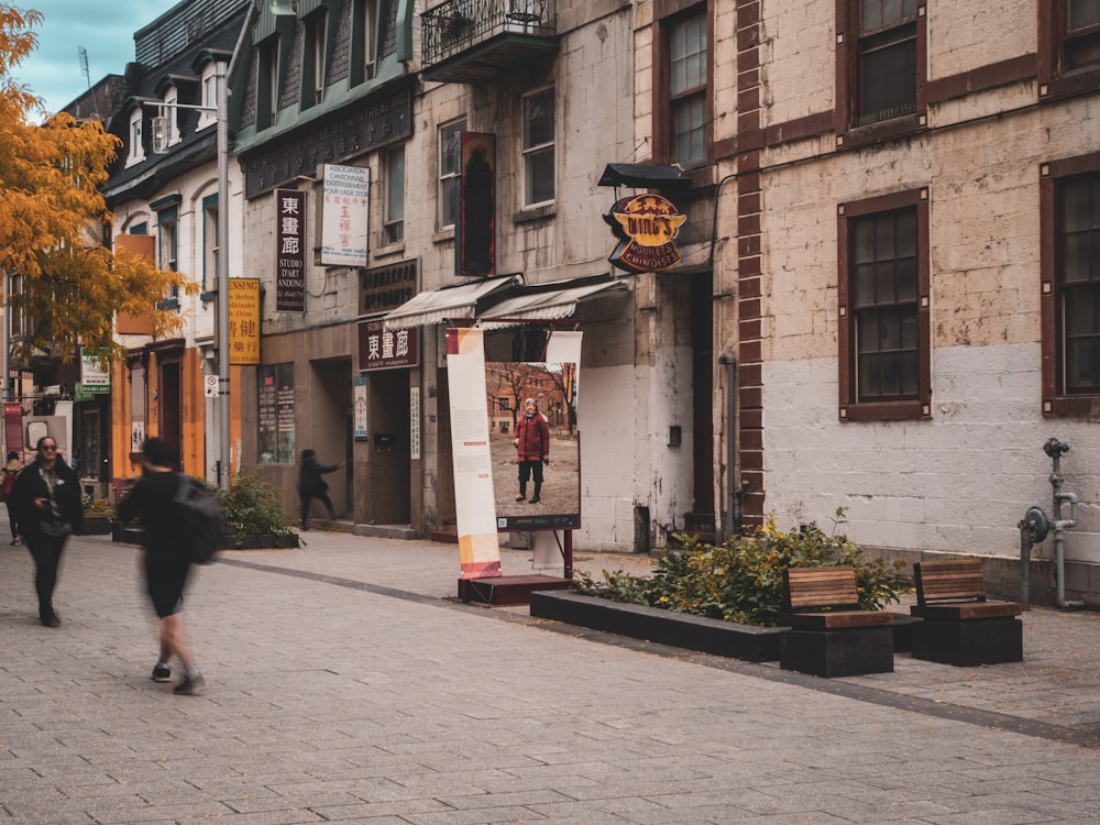 a person walking down a street next to tall buildings