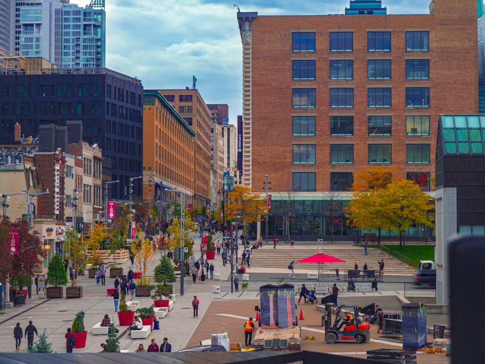 a group of people walking down a street next to tall buildings