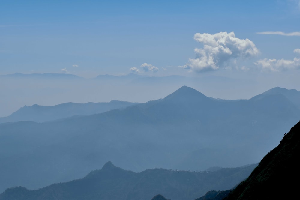 a view of a mountain range with a cloud in the sky