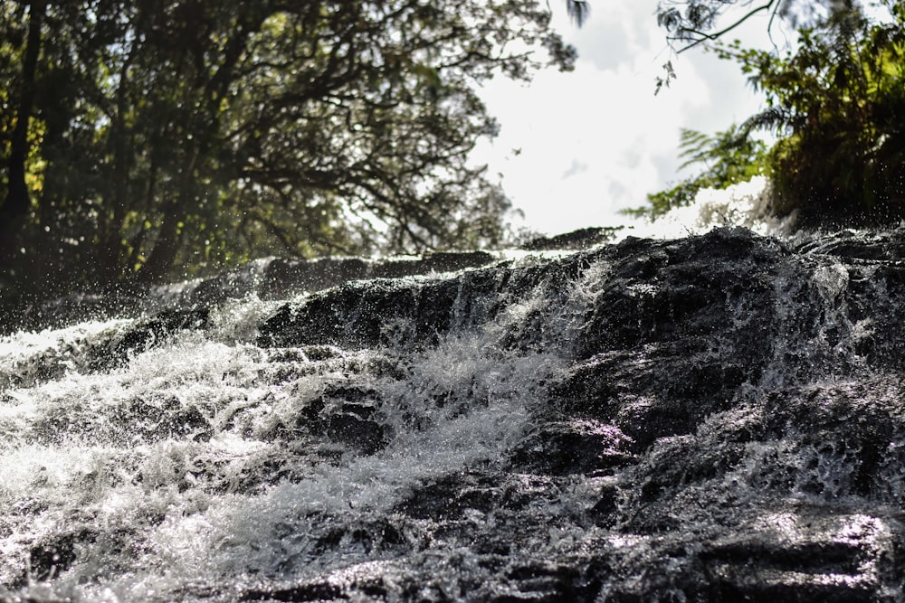 a man riding a surfboard on top of a waterfall