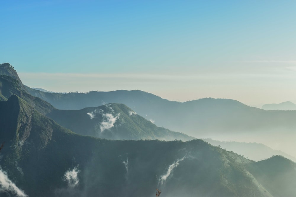 a view of a mountain range with mist in the air