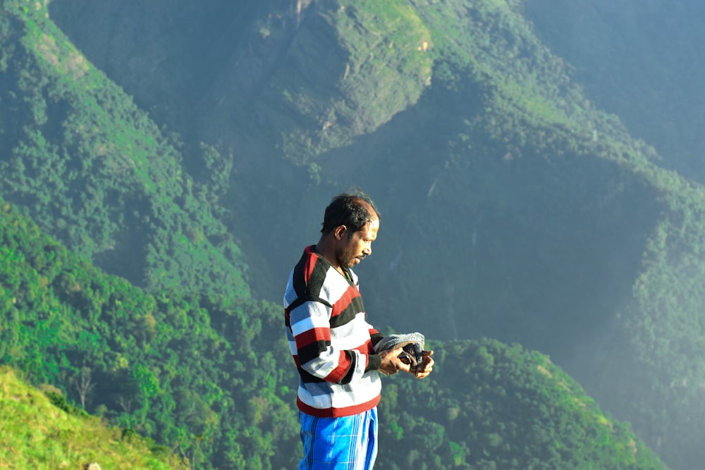 a man standing on top of a lush green hillside