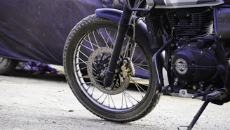 Suspension components of a motorcycle with a blurred road background.
