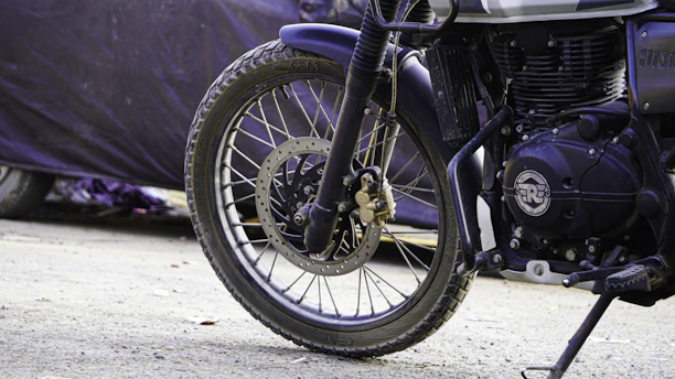 Suspension components of a motorcycle with a blurred road background.