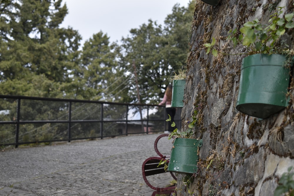 a woman standing next to a stone wall