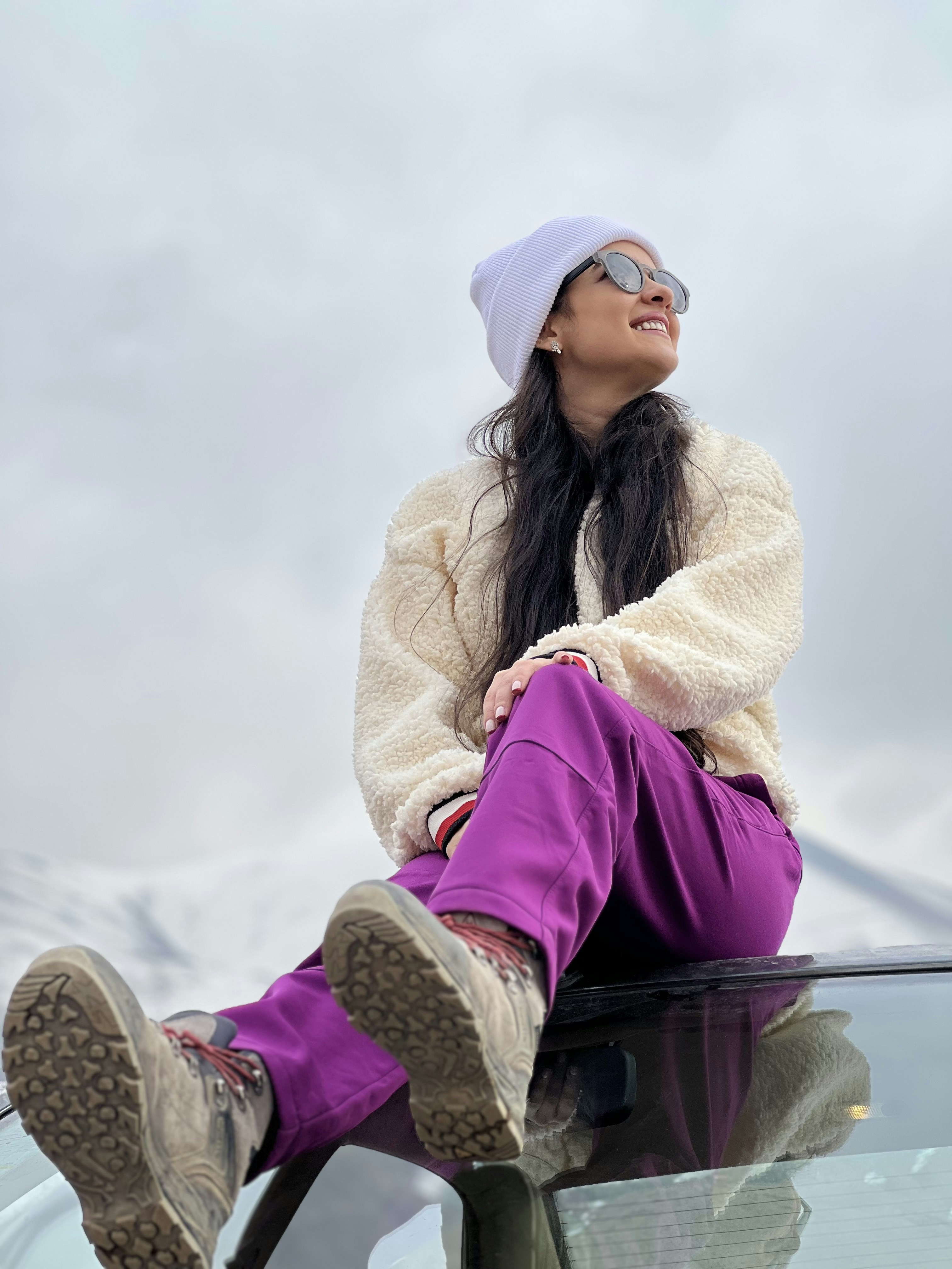 a woman sitting on the hood of a car