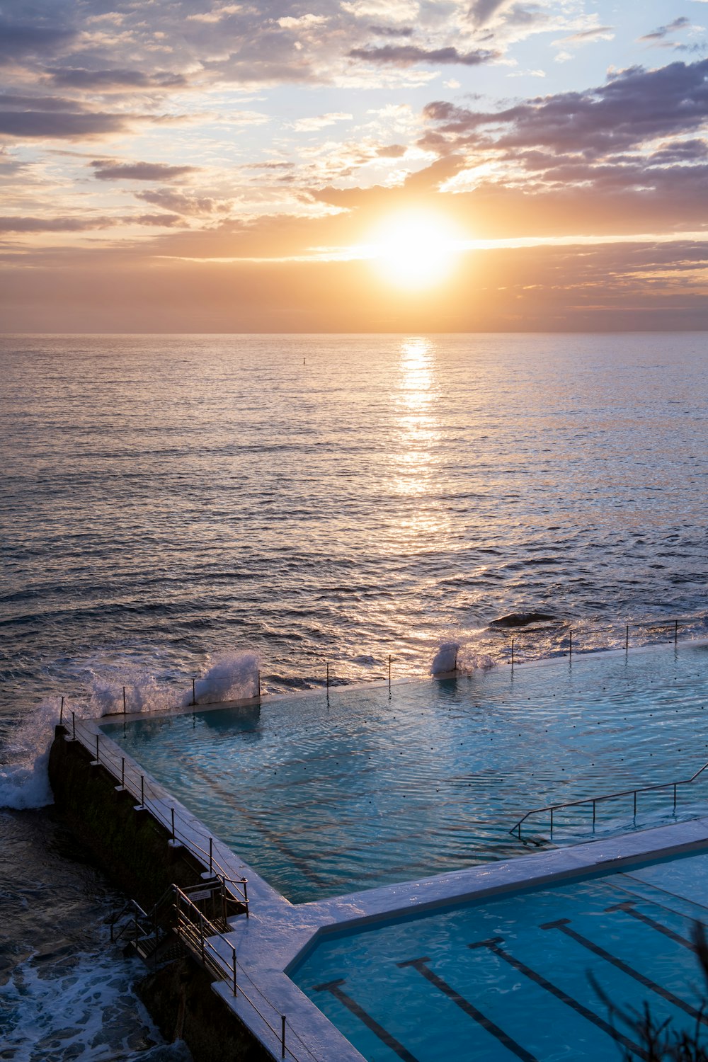 a large swimming pool with a sunset in the background