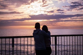 Father and son sharing a quiet moment watching the sunset from a balcony.