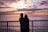 A happy couple standing on a balcony overlooking the Baltic Sea at sunset.