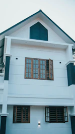 Exterior of a modern house in Guwahati with vibrant blue and white paint.