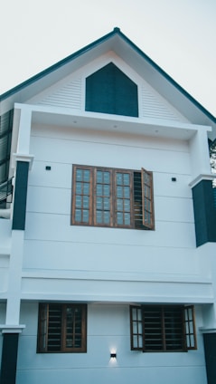 A freshly renovated two-story home with dark blue exterior and neon accent lighting at dusk.