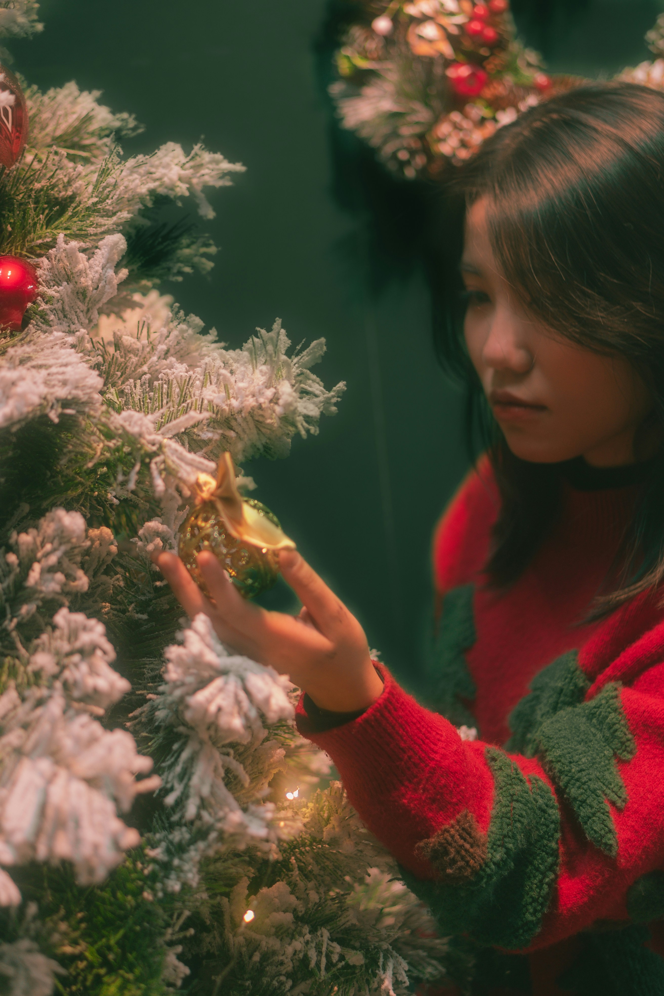 a young girl decorating a christmas tree