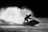 Dynamic shot of a rider smoothly gliding over water with the vortex upgrade kit visible, set against a dark, moody sky.