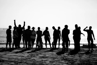 a group of people standing on top of a sandy beach