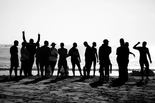 a group of people standing on top of a sandy beach