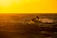 Close-up of a sleek jet ski with gold-accented accessories gliding over dark ocean waters at sunset.