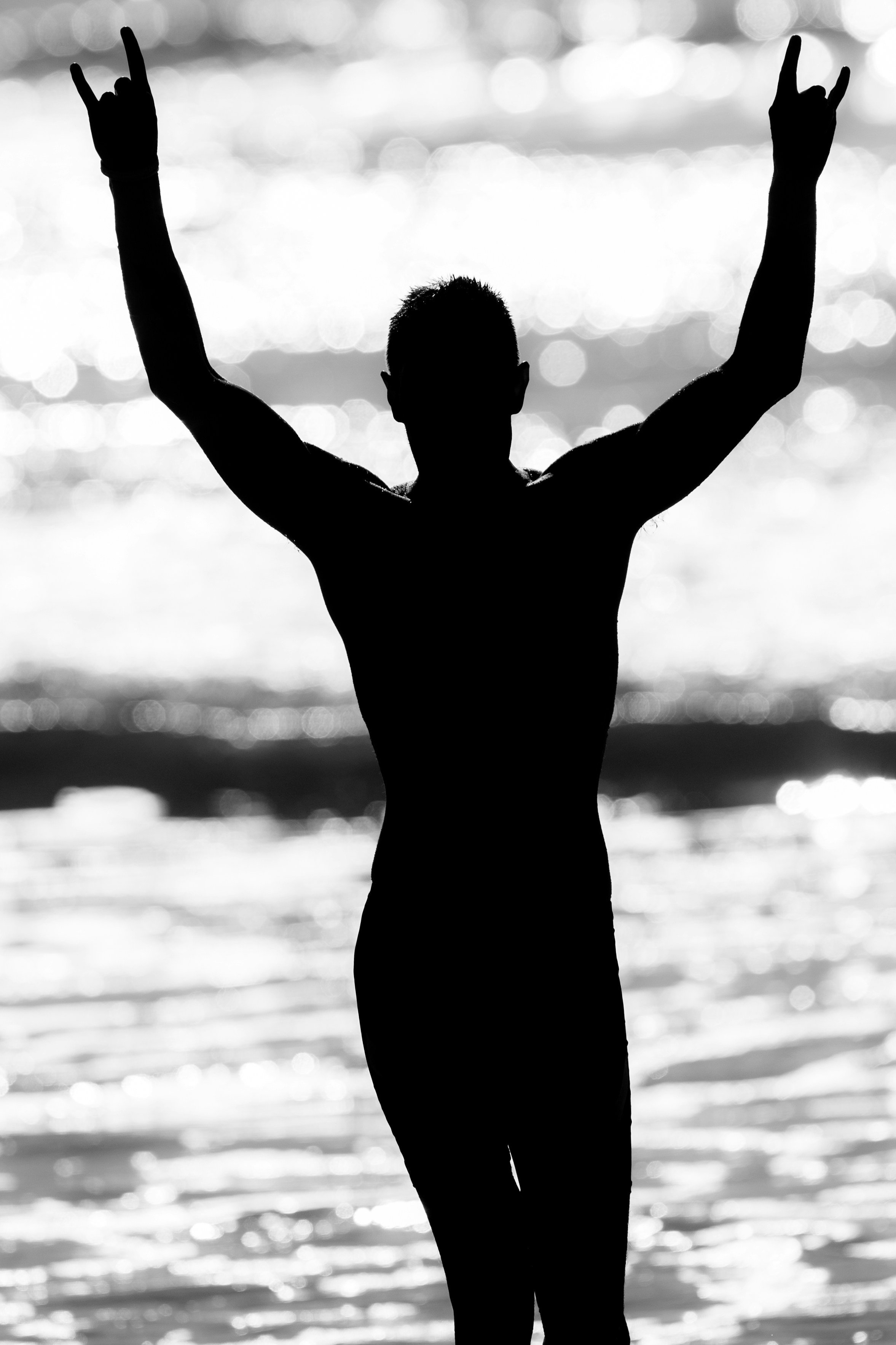 A man standing in the water with his arms in the air photo – Free Man ...