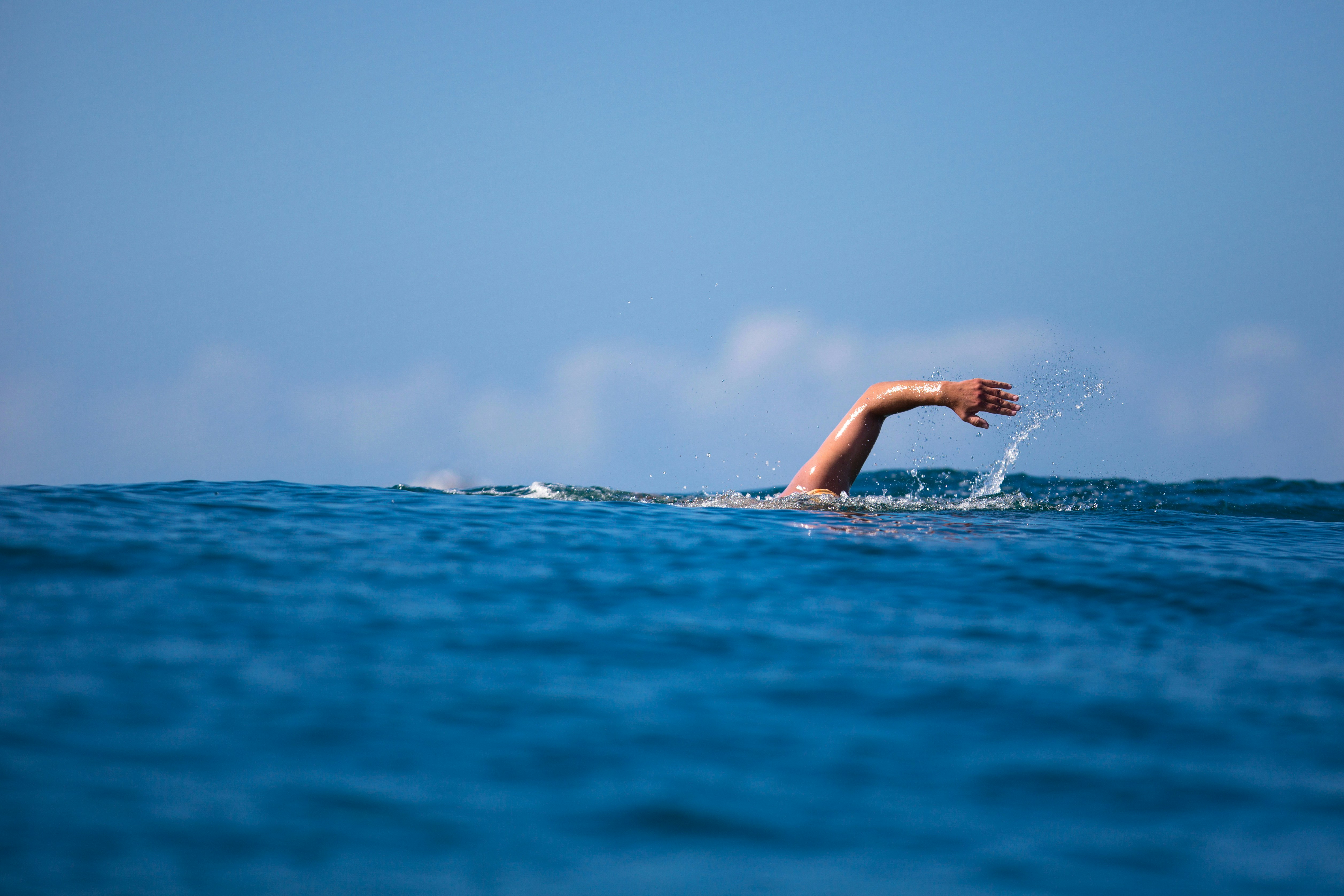 a person swimming in the ocean with their arm out