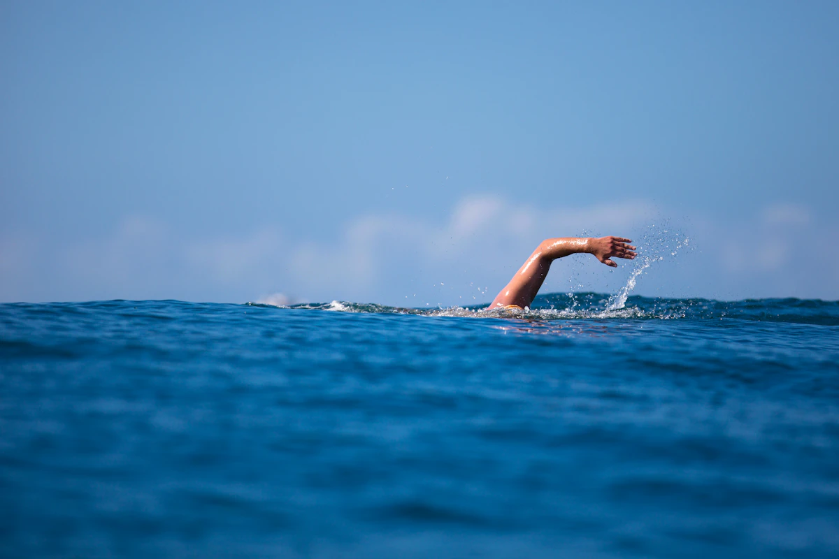 a person swimming in the ocean with their arm out