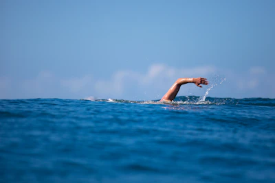 a person swimming in the ocean with their arm out