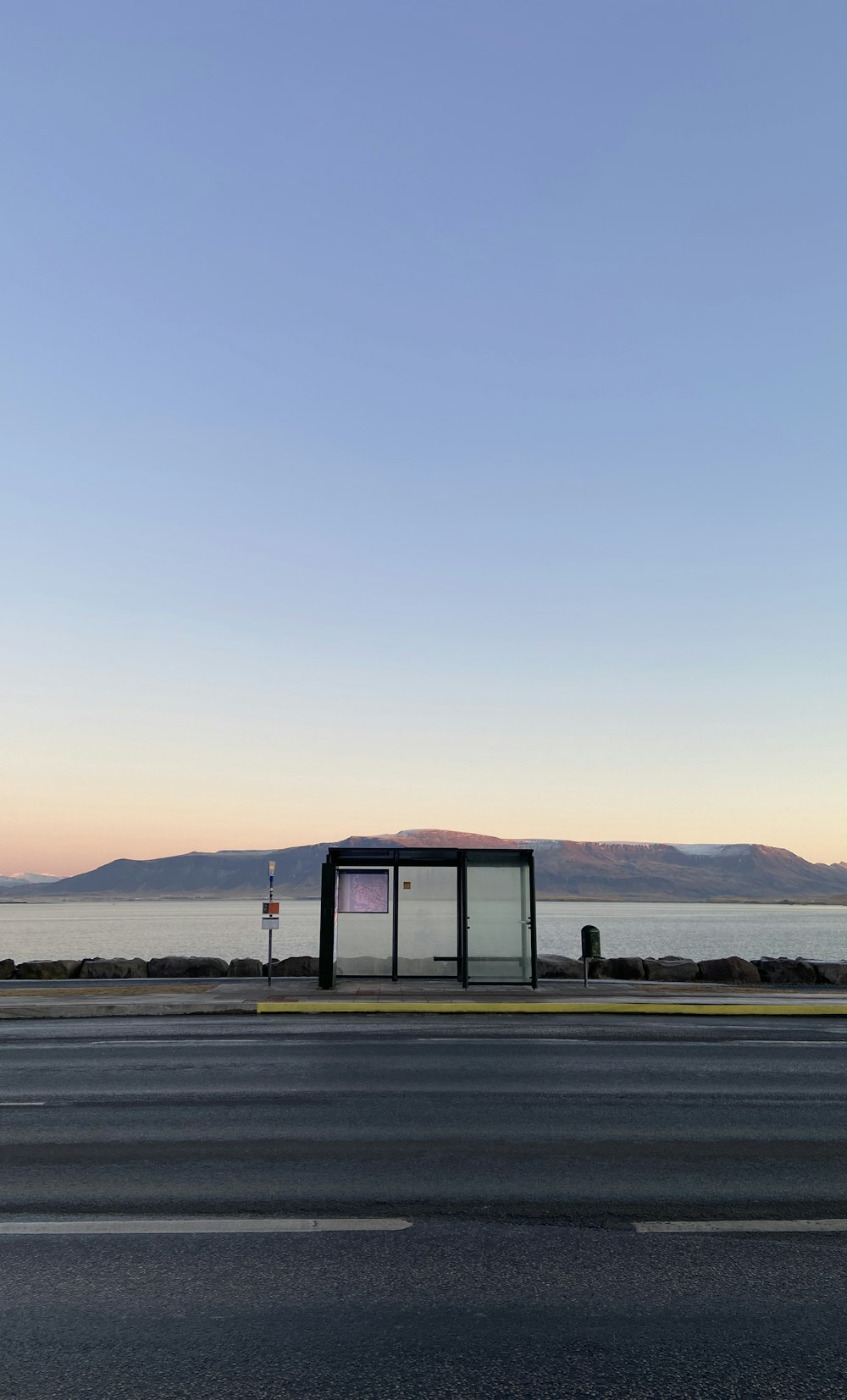 a bus stop sitting on the side of a road