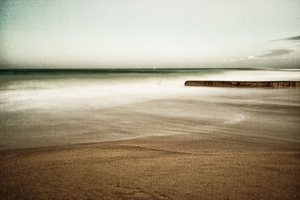 a sandy beach with waves coming in and out of the water