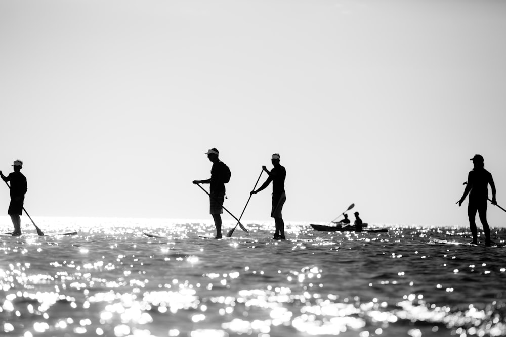 a group of people riding paddle boards on top of a body of water