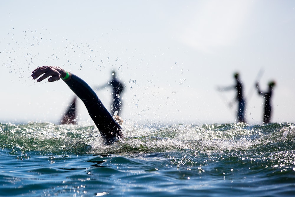 a person in a wet suit swimming in the ocean