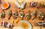 A rustic wooden board displaying an assortment of international holiday appetizers with bold flavors.