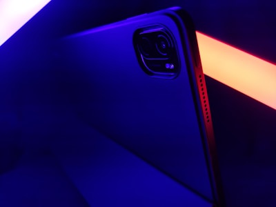 Dynamic photo showing vibrant mobile phones with colorful gradients illuminated by soft studio lighting.