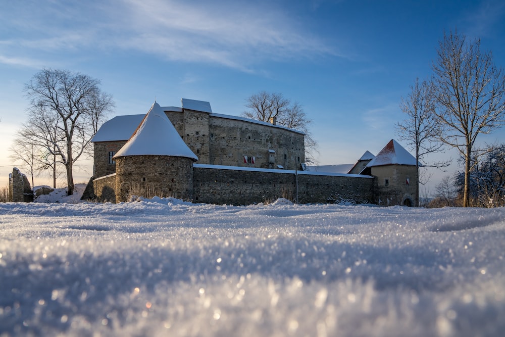 a castle in the middle of a field covered in snow