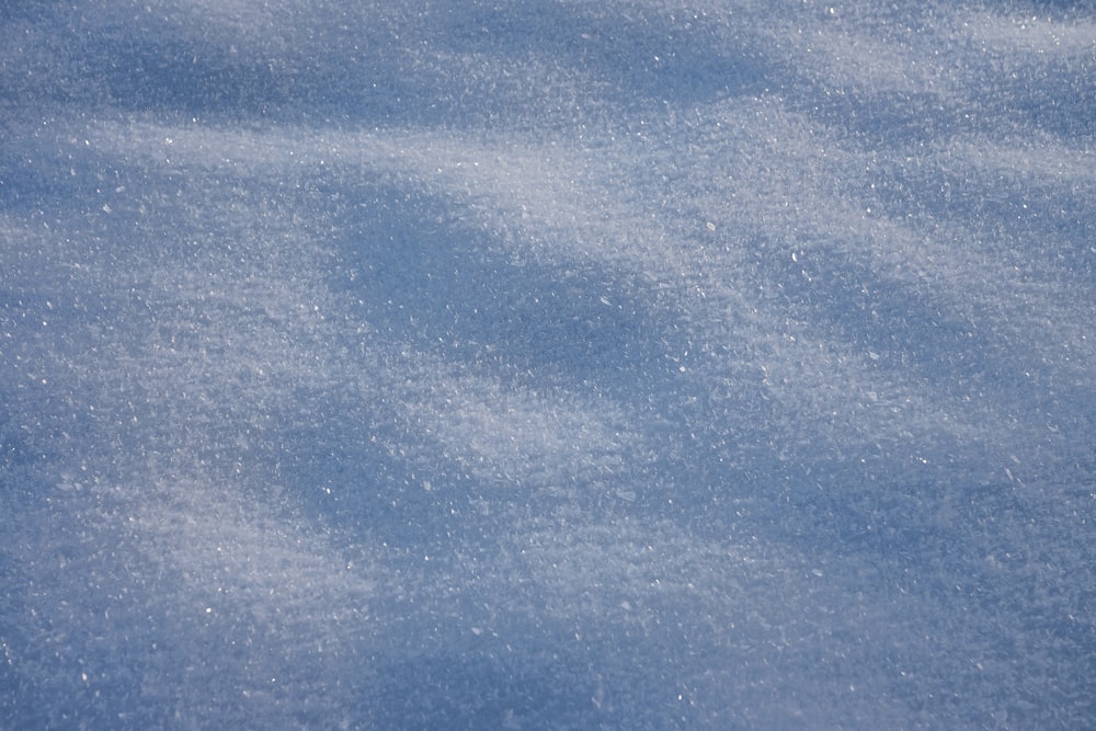 a snow covered ground with a blue sky in the background